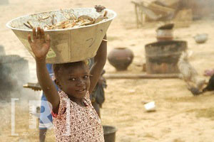Malinese girl carrying fish
